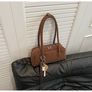 Detailed view of brown matte leather shoulder bag with zipper and logo branding