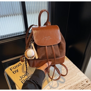 Detail of retro brown patchwork mini backpack with drawstring and baseball charm