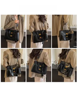 Detail view of black leather tote bag featuring gold square locks and adjustable shoulder strap