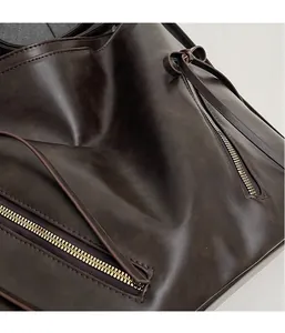 Detail of dark brown leather texture with golden zipper and decorative bow knot
