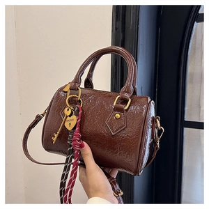 Detail of Boston bag showing wrinkled leather texture, heart padlock, and woven strap