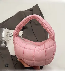 Close-up of pink quilted cloud bag with padded handle for trendy urban commute style