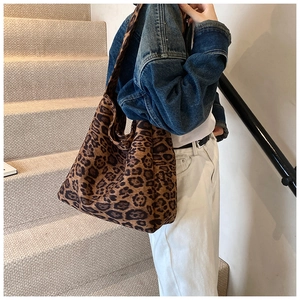 Fashionable large capacity leopard print tote bag shown on model in a casual indoor setting