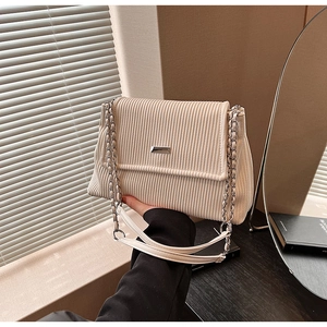 Détail du sac cabas en velours côtelé crème avec texture plissée et bandoulière chaîne