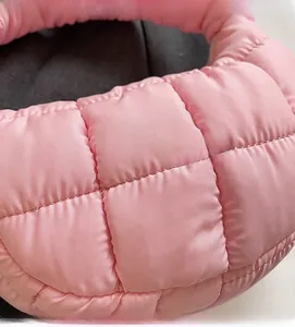 Detail of pink quilted puffer shoulder bag showing lightweight glossy nylon fabric texture