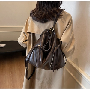 Detail view of the brown vintage leather backpack showing soft texture and strap design