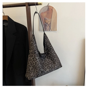 Detail view of large leopard print tote bag in soft material hanging on a rack
