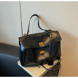 Detail of black leather tote bag with vintage gold twist locks on business layout