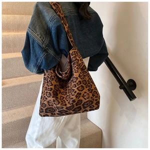 Leopard print hobo bag worn by a model in a stylish casual outfit on stairs