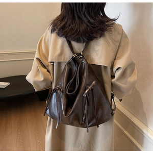 Detailed back view of a dark brown vintage large capacity backpack on a model's shoulder
