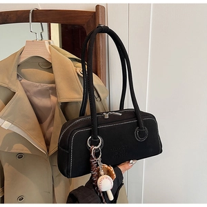 Detail of black Boston style shoulder bag with contrast white stitching and baseball charm