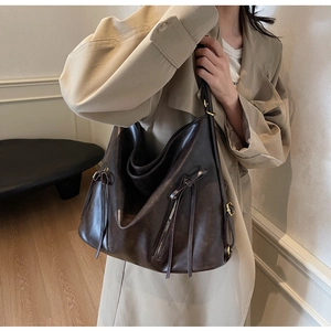 Deep coffee large capacity tote bag with decorative straps shown in a lifestyle setting