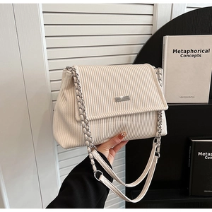 Détail du sac cabas en velours côtelé crème avec bandoulière chaîne et fermoir métal
