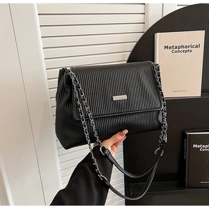 Détail du sac cabas plissé noir montrant les textures et la bandoulière chaîne argentée
