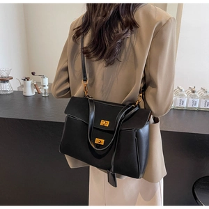 Chic black leather tote bag with dual gold twist locks and adjustable shoulder strap