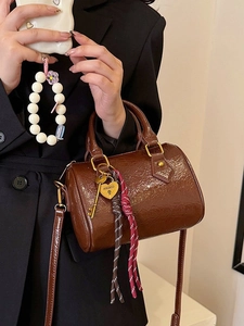 Brown Boston pillow handbag with vintage key and heart charms in a glossy leather finish