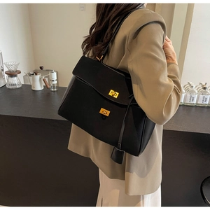 Macro detail of high-quality black suede tote bag with elegant golden square metal buckles