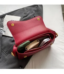 Interior view of deep red leather shoulder bag showing multiple storage compartments