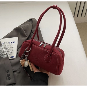Detail of burgundy suede shoulder bag with MUHETI SHI SHANG logo and baseball charm