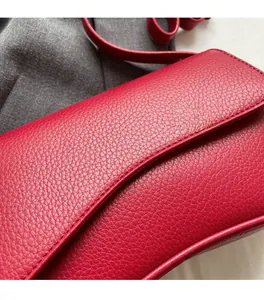 Macro shot of red lychee pattern leather shoulder bag showing detailed stitching quality