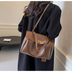 Brown leather tote bag featuring a gold metal twist lock and a sleek shoulder strap