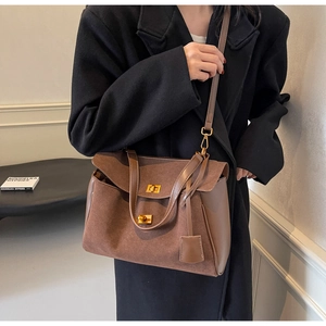 Detail of vintage brown tote bag with suede and leather patchwork and metal buckle