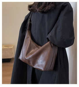 Détail du sac seau en cuir PU marron vintage avec bandoulière réglable sur l'épaule