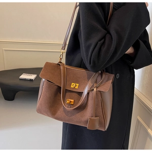 Close-up of vintage dark brown tote bag with suede texture and gold twist-lock buckles