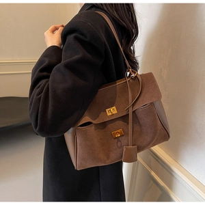 Detail of vintage brown tote bag with suede patchwork and golden metal turn-locks