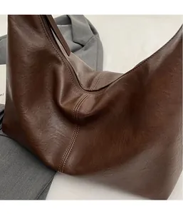 Détail de la texture en similicuir marron foncé et surpiqûres du grand sac fourre-tout