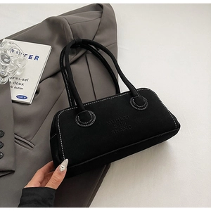 Detail view of black rectangular handbag with white contrast stitching and embossed logo
