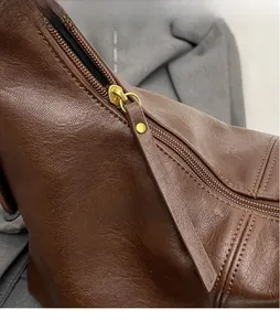 Détail du sac en cuir marron vintage avec quincaillerie dorée et couture fine