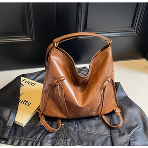 Detail view of vintage dark brown faux leather bag with bow tie and gold hardware
