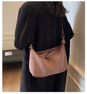 Détail d'un sac cabas vintage en daim marron avec fermeture éclair sur l'épaule