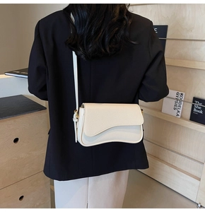 Detail of off-white lychee grain leather shoulder bag with asymmetrical curved flap