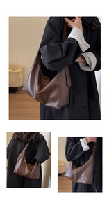 Détail macro d'un grand sac hobo marron montrant sa texture en similicuir et son design épuré