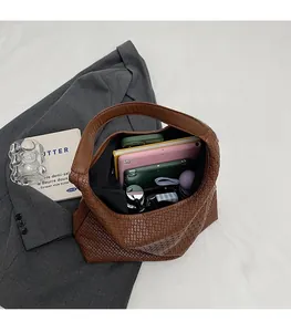 Vue détaillée du grand intérieur du cabas tissé marron avec accessoires quotidiens