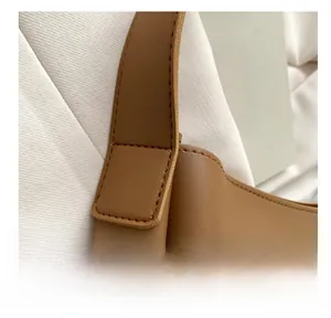 Detail view of reinforced stitching on brown leather shoulder bag strap with premium finish
