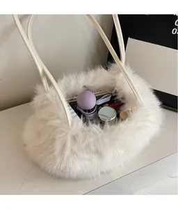 Vue de dessus du sac seau en fausse fourrure blanche montrant un intérieur spacieux et des objets