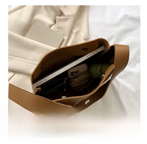 Spacious brown leather tote bag interior showing capacity for books, phone, and umbrella