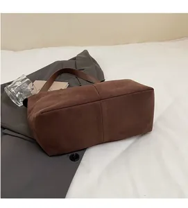 Vue détaillée du sac cabas en simili daim marron foncé sur un blazer gris chic
