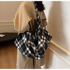 Détail du grand sac hobo à carreaux noir et blanc en laine épaisse avec anneau métal