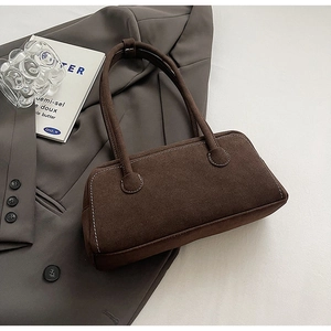 Detail view of brown suede shoulder bag featuring contrast white stitching and minimalist design
