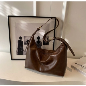Détail d'un grand sac cabas rétro en cuir marron foncé avec bandoulière réglable