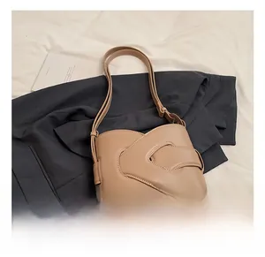 Detail showing the overlapping layered design of this chic beige PU leather bucket bag