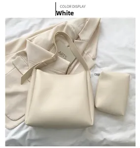 Close-up of a cream white tote bag set with a matching small zipper pouch on a soft fabric