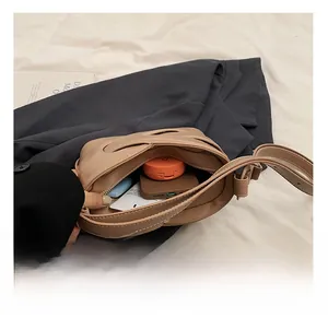 Top view showing the spacious interior of the khaki bucket bag with daily essentials