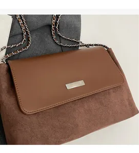 Detail of brown patchwork shoulder bag with leather flap and textured suede body