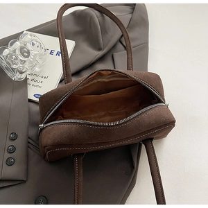 Detail view of coffee suede underarm bag interior with contrast stitching and pocket