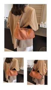 Gros plan détaillé du sac à bandoulière en daim marron foncé avec sangle et boucle en métal